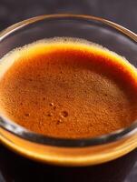 Close up of Espresso Crema in a Glass. A Detailed Image Showing the Rich Texture and Color of Freshly Brewed Espresso. photo