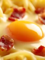 Close up of a Fried Egg Yolk on Pasta with Bacon photo