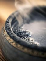 Close up of black chia seeds in a stone bowl with steam rising, evoking a sense of warmth and well-being. photo