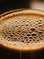Close Up of Golden Bubbles on Dark Liquid Surface. A detailed macro photograph of a textured liquid with illuminated bubbles. photo