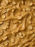 Swirled Peanut Butter with Roasted Peanuts. A close up image of creamy peanut butter with scattered peanuts. photo