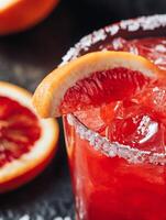 Close up of a refreshing blood orange margarita with a salted rim. photo