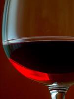 Close Up of Red Wine in a Glass Against a Dark Background. A Dramatic Image of a Wine Glass. photo