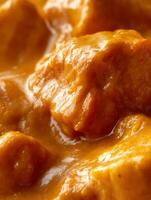 Close Up of Creamy, Golden Curry Sauce with Chunks of Meat. photo