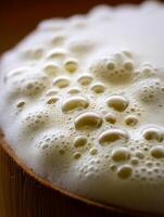 Close Up of Creamy Beer Head in Wooden Mug. A detailed image showing the texture and bubbles of a frothy beer head. photo