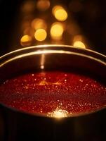 Close up of Glittering Red Liquid in a Metal Bowl with a Bokeh Background. photo