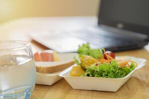 Shot of office worker desk with healthy with mixed fruit and vegan ingredients. photo
