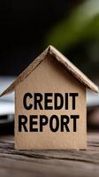Paper house displaying credit report letters reflects financial management themes in a creative setup photo