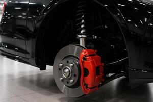 Detailed view of modern car disc brake and suspension system with red caliper photo