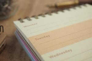Weekly planner open on a wooden desk for organization photo