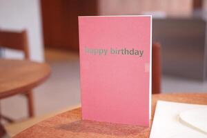 Birthday card displayed on a wooden table in a cozy setting photo