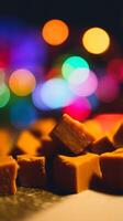Close Up of Golden Brown Caramel Cubes Against a Colorful Bokeh Background. photo