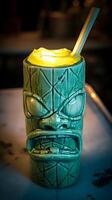 Tiki Mug Filled with Illuminated Cocktail. A close up shot of a green tiki mug containing a vibrant yellow cocktail, lit from within. photo