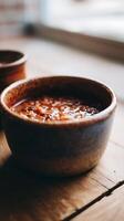Close up of a bowl of hearty chili on a wooden surface. photo