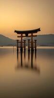 Serene Sunset at the Iconic Floating Torii Gate. A breathtaking image of a Japanese shrine gate in calm waters at golden hour. photo