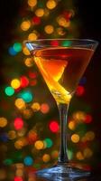 Festive Cocktail in Martini Glass with Christmas Lights Bokeh. A close up image of a delicious alcoholic beverage garnished with an orange twist, set against a shimmering background of colorful holiday lights. photo