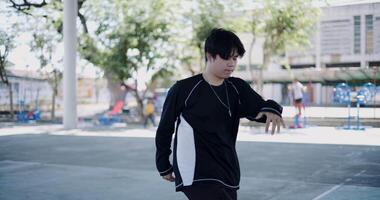 Handheld steady shot, Young Asian man is practicing hip-hop and other freestyle dances with determination under a dome in a park. Weekend Hobbies video