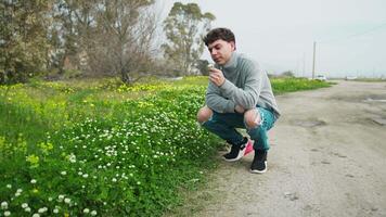 Man Picking And Looking A White Flower From The Grass During Autumn video
