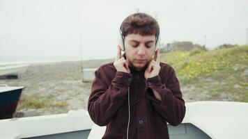 Man Relaxing On The Shore During Winter While Listening To Music video