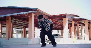 Handheld wide view shot, Young Asian man with dancing skills is practicing new moves by himself. Enjoy the rhythm and creativity. Solo dance. video