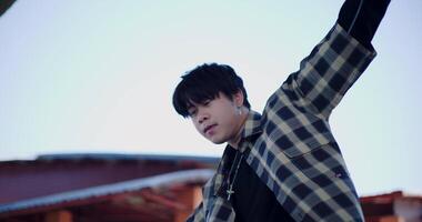 Handheld low angle view shot, Stylish Asian man freestyle dances solo under a public dome in the open air. Solo dance. Full energy. Holiday activity. video