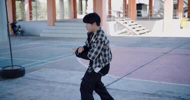 Handheld shot, Asian man with dancing skills is practicing new moves by himself. Enjoy the rhythm and creativity. Solo dance. video