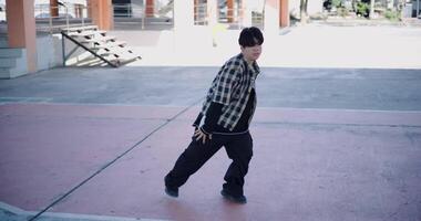 Handheld high angle view shot, Young man with dancing skills is practicing new moves by himself. Holiday activity. Solo dance video