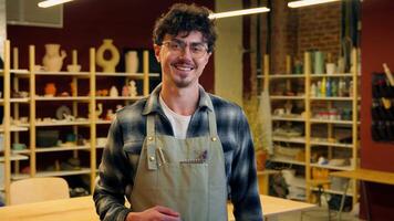 Caucasian smiling man potter artisan craftsman invite come here invitation pottery workshop master class male joyful guy small business owner sculptor allure beckon in craft store ceramics artwork video
