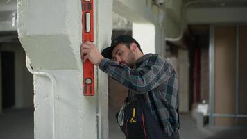Caucasian builder foreman architect man measure ruler wall of building construction male engineer technician handyman measuring doubt think problem renovation mistake confused trouble measurements video