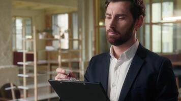 Pensive businessman thoughtful Caucasian business man writing notes in office workplace text thinking idea consider write bank papers contract deal sign planning middle-aged male guy employee ponder video