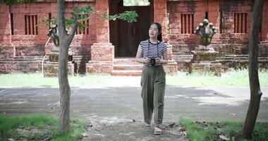 Handheld shot, Cheerful young woman is enjoying a quiet walk while taking pictures of the surrounding nature, Enjoy holiday travel. video