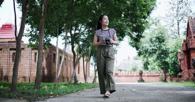 Low angle view shot, Happy young woman is enjoying a quiet walk while taking pictures of the surrounding nature, Enjoy holiday travel. video
