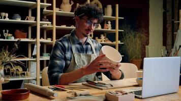 Potter man artisan sculpting handmade bowl male artist sculptor craftsman designer Caucasian guy smiling create plate sell ceramics craft small business owner showing thumb up gesture pottery workshop video