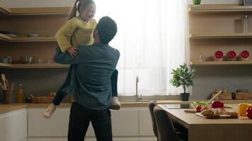 Happy family at kitchen in morning little daughter running to dad father rising up child kid girl spinning around rotation hugging cuddling touch noses bonding affection childcare custody devotion video