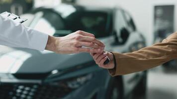 The car dealer hands the car keys to a woman a moment of purchasing a new car or car rental. Concept a pivotal moment in the transaction, reflecting the significance of a rental or high-value purchase video