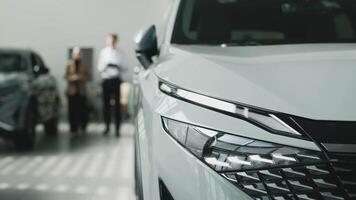 The concept of an expensive purchase or lease of a modern car. A car dealer advises a client on the purchase of a new car at a car dealership. video