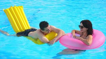 Man and woman enjoying a hot summer day in an outdoor pool. Concept relaxation, togetherness, summer mood. video