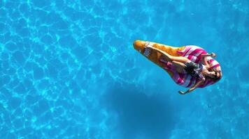 Young woman enjoying vacation while relaxing on a mattress in a swimming pool. Concept freedom, summer relaxation. Shot from drone. video