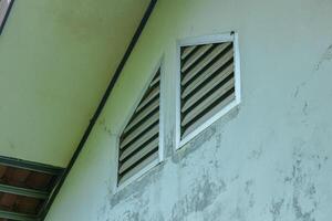 Building Exterior with Louvered Windows and Textured Wall photo