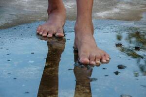 Bare Feet Walking Through Puddle with Reflections photo