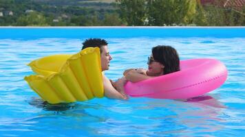 Young couple enjoying a warm summer day in the swimming pool. Concept relaxation, love, summer vibes. video