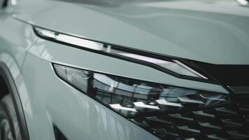 Close-up of car headlights in an automobile showroom. An advanced design concept that improves visibility, demonstrates innovation and adds style to nighttime driving. video
