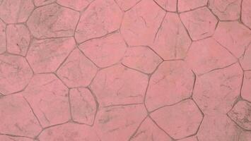 A pink cobblestone pavement with irregular shapes and dark gray grout lines, creating a textured and patterned surface, ideal for backgrounds photo