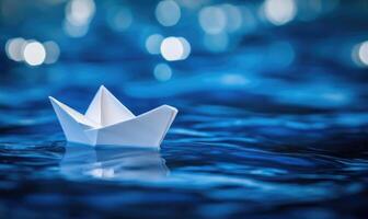 Paper boat on blue water photo