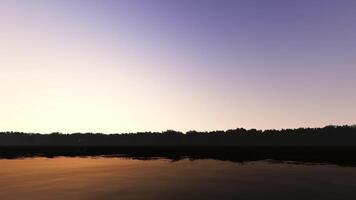 A lake with trees and a sunset in the background video