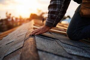 A close-up image of a home repair, focusing on a roofer installing shingles on a roof. photo
