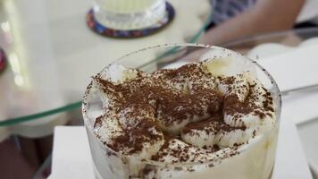 Sprinkling Cocoa on Creamy Dessert in a Glass Cup video
