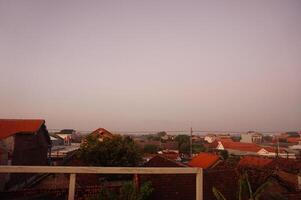 A view of the rooftops of a town at dusk photo