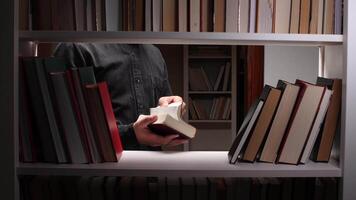 Man reading a book in a library surrounded by bookshelves video