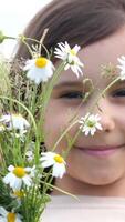 A young girl is smiling while holding a bunch of daisies video